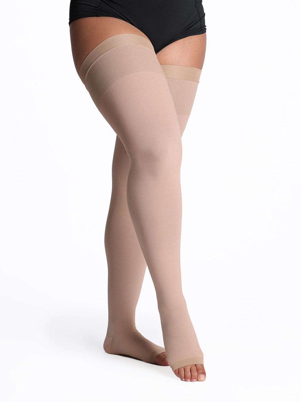 Female wearing SPECIALTY NATURAL RUBBER open toe compression thigh highs in BEIGE